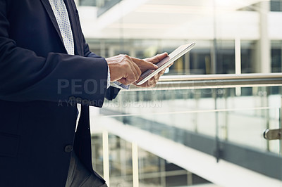 Buy stock photo Cropped shot of a unrecognisable male businessman using a digital tablet inside of a building