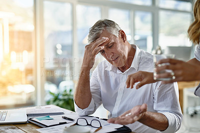 Buy stock photo Business, headache and medicine for mature man in office with help from assistant or employee. Glass, pill or stress and overworked corporate manager in workplace with symptoms of burnout migraine