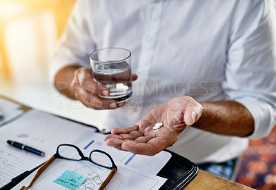 Buy stock photo Cropped shot of an unrecognizable businessman taking a pill for his headache in the office