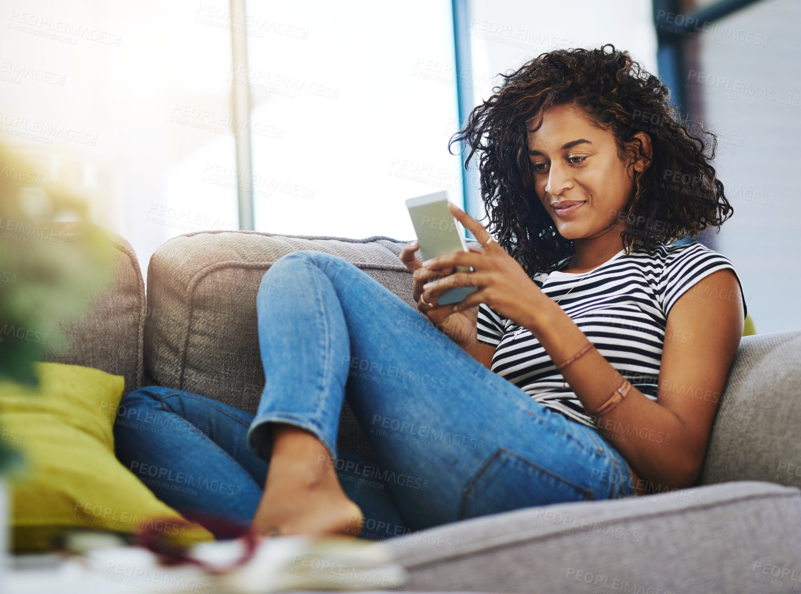 Buy stock photo Shot of an attractive young woman relaxing at home on the weekend