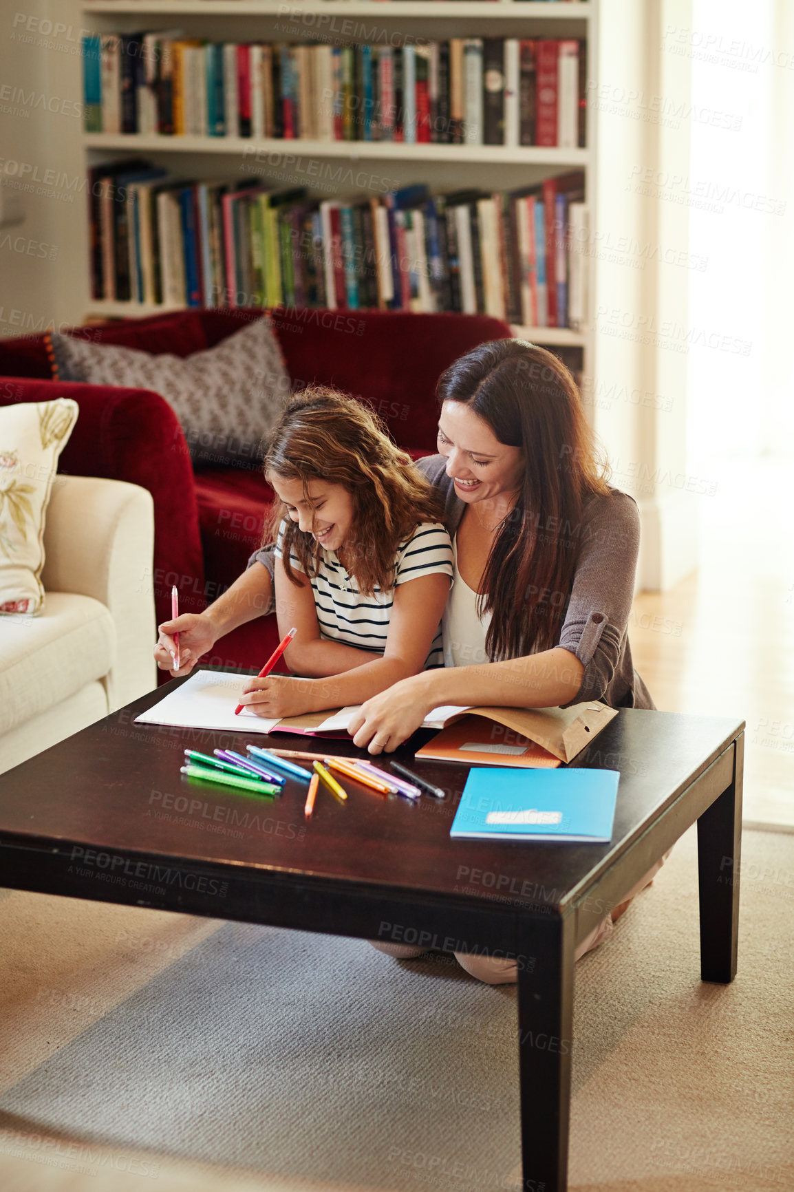 Buy stock photo Shot of a beautiful mother helping her adorable daughter with her homework at home