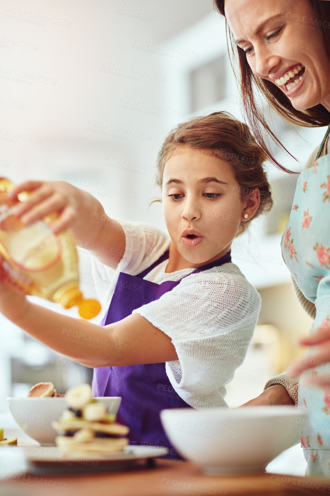 Buy stock photo Shot of a mother and daughter preparing food in the kitchen at home