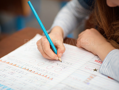 Buy stock photo Closeup shot of an unidentifiable elementary school girl writing in her notebook in class
