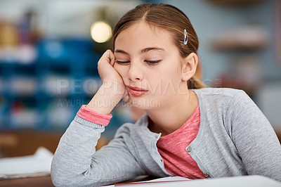 Buy stock photo Shot of a young elementary school girl looking bored while sitting in class