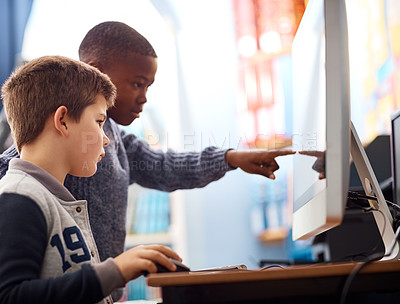 Buy stock photo Shot of elementary school kids using a computer while working in class