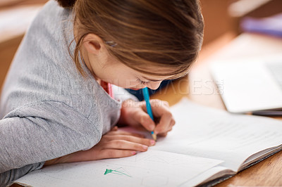 Buy stock photo Shot of an elementary school girl writing in her notebook in class