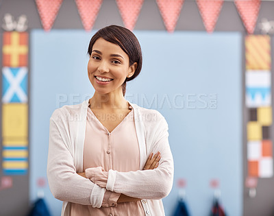 Buy stock photo Portrait of a young female teacher standing in a classroom