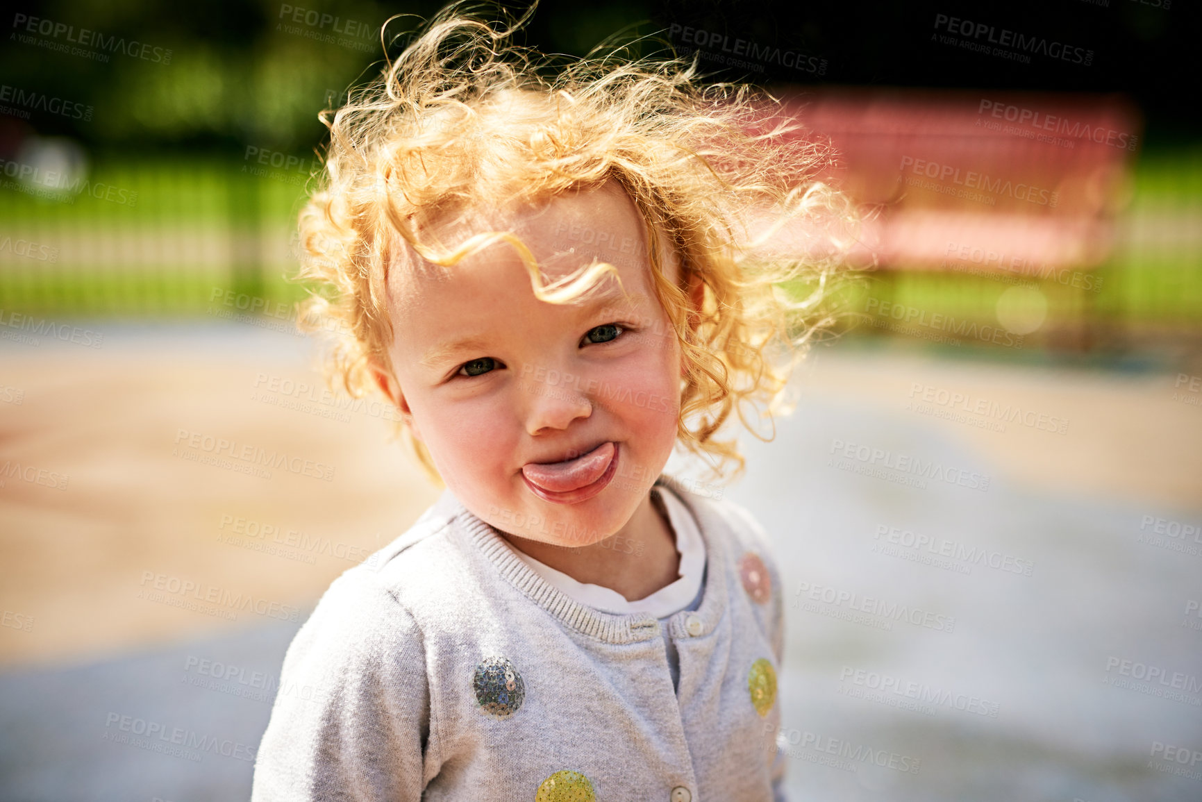 Buy stock photo Portrait of an adorable little girl sticking her tongue out outdoors