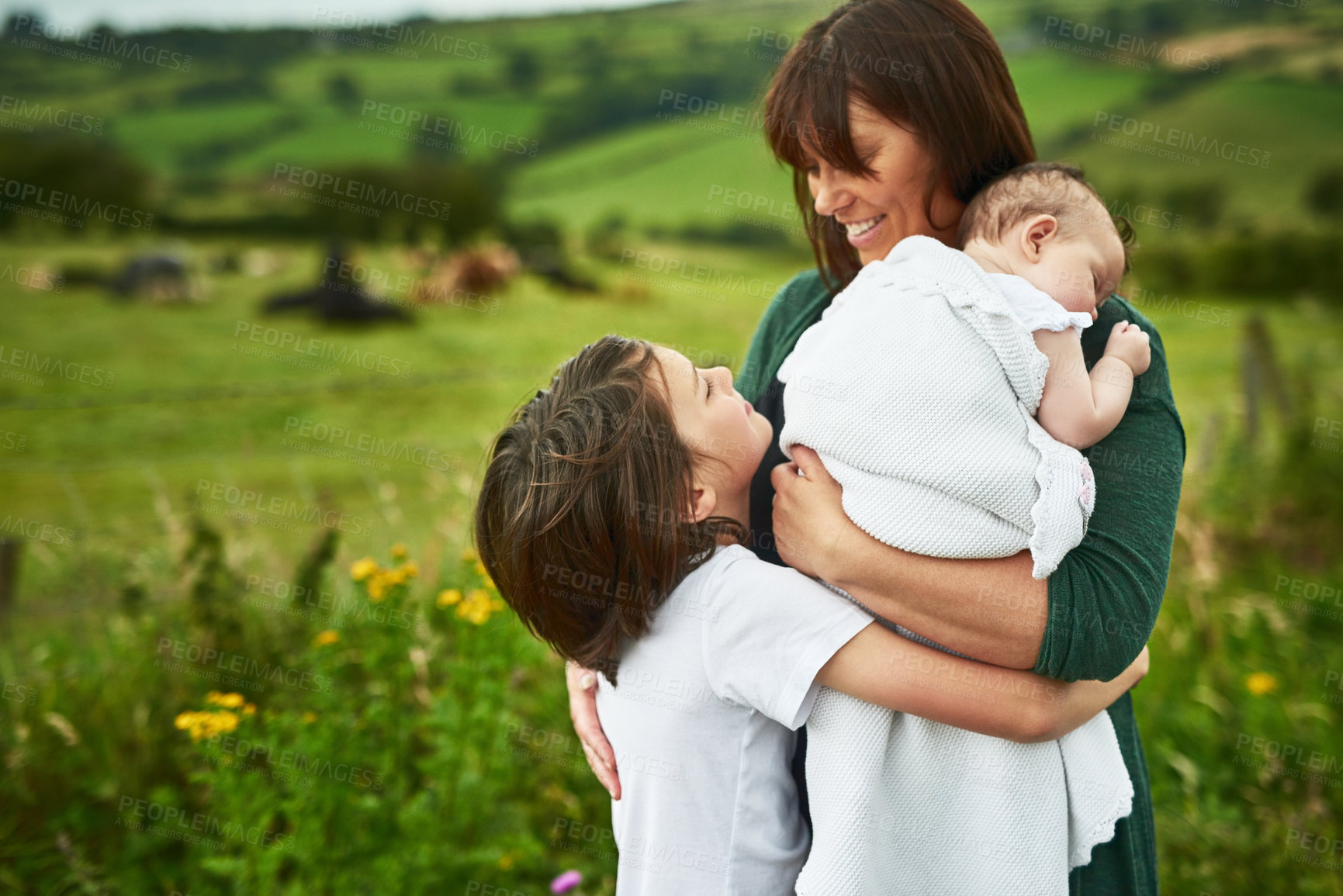 Buy stock photo Smile, mother and children hug outdoor for love, care and bonding together with people on family holiday. Mom, happy kids and embrace in countryside with baby for support, connection and parenthood