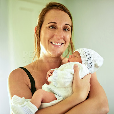 Buy stock photo Portrait of cheerful young mother holding her infant son while looking into the camera at home