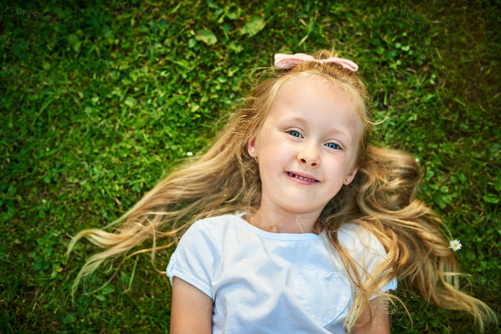 Buy stock photo Girl, portrait and top view of child on grass, outdoor freedom and relax on backyard lawn. Female person, England and peace in countryside nature on holiday, calm kid and toddler for vacation in park