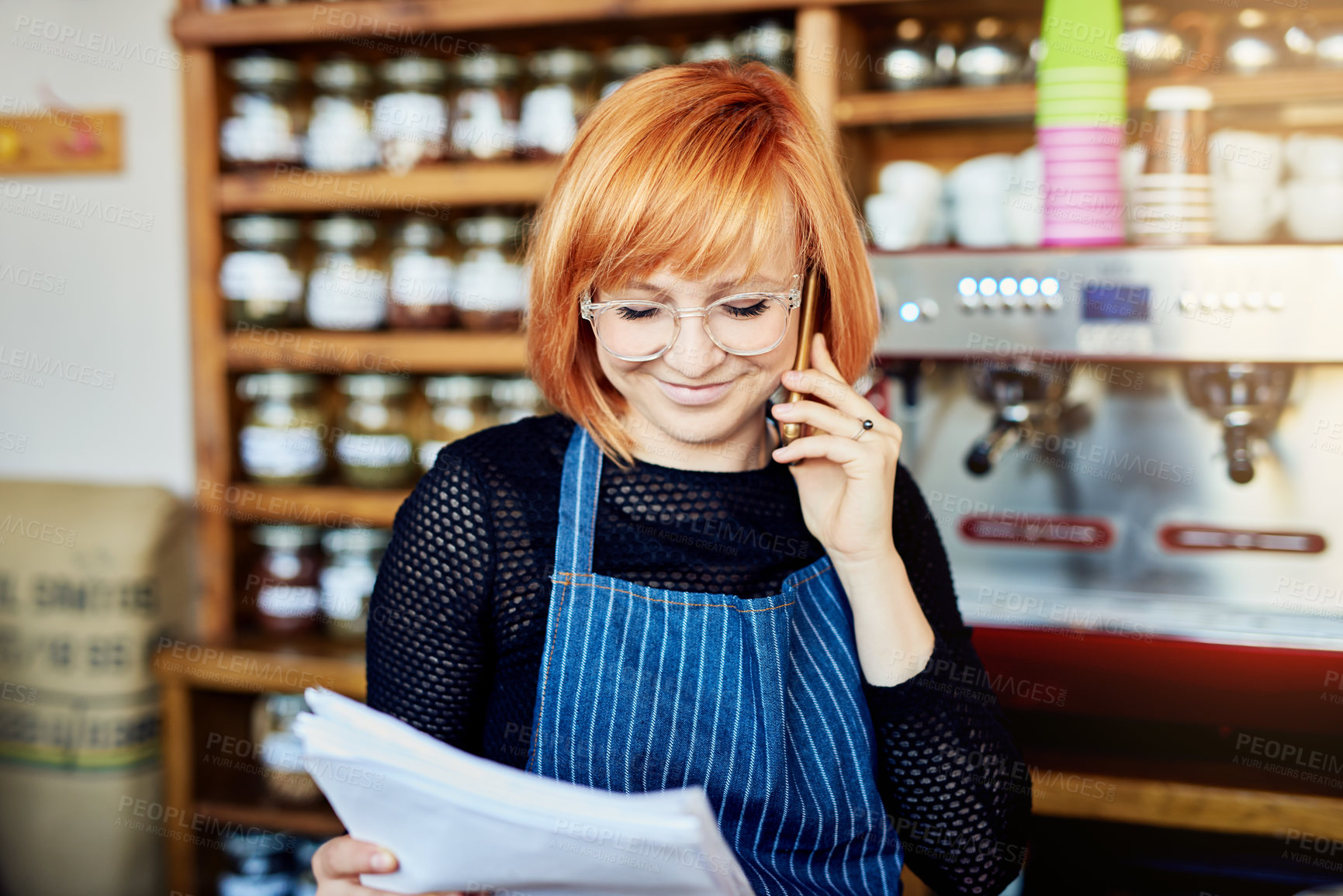 Buy stock photo Woman, phone call and coffee shop with paperwork, reading and smile for order, stock and deal with supplier. Person, business owner and smartphone with documents, invoice and inventory in cafeteria