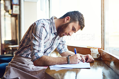 Buy stock photo Coffee shop, writing and man with documents by window for inventory, menu items and stock checklist. Restaurant, small business and person with paperwork for planning, budget review and cafe products