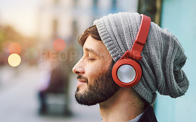 Buy stock photo Relax, smile and man with headphones for music, radio or a podcast in the city. Happy, freedom and a young person sitting, enjoying and listening to audio, calm songs or zen sound while downtown