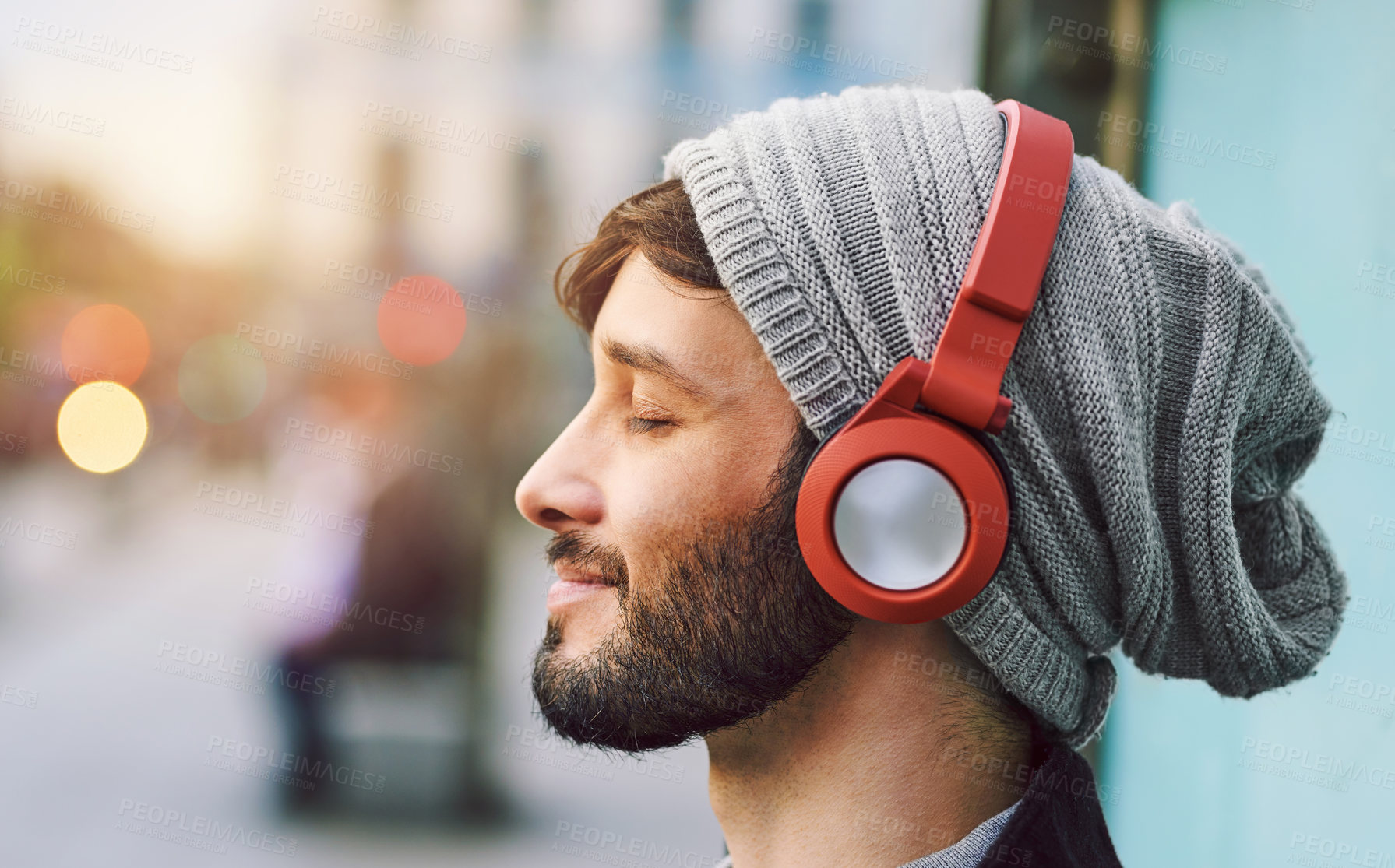 Buy stock photo Relax, smile and man with headphones for music, radio or a podcast in the city. Happy, freedom and a young person sitting, enjoying and listening to audio, calm songs or zen sound while downtown