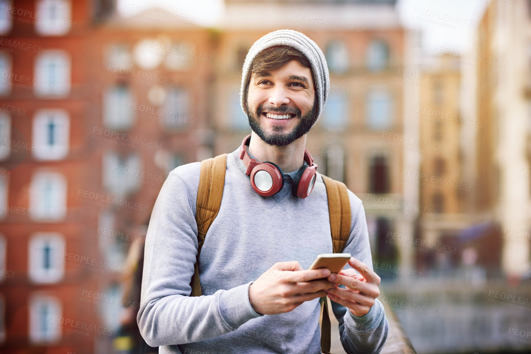 Buy stock photo Shot of a young man using his mobile phone while out in the city