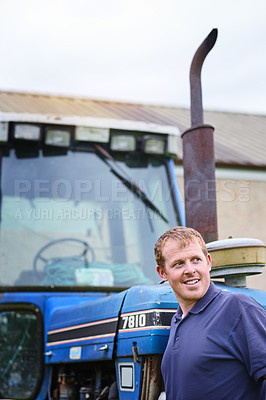 Buy stock photo Shot of a farmer standing next to a tractor on a farm