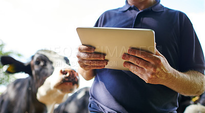Buy stock photo Cropped shot of a farmer using a digital tablet on his farm