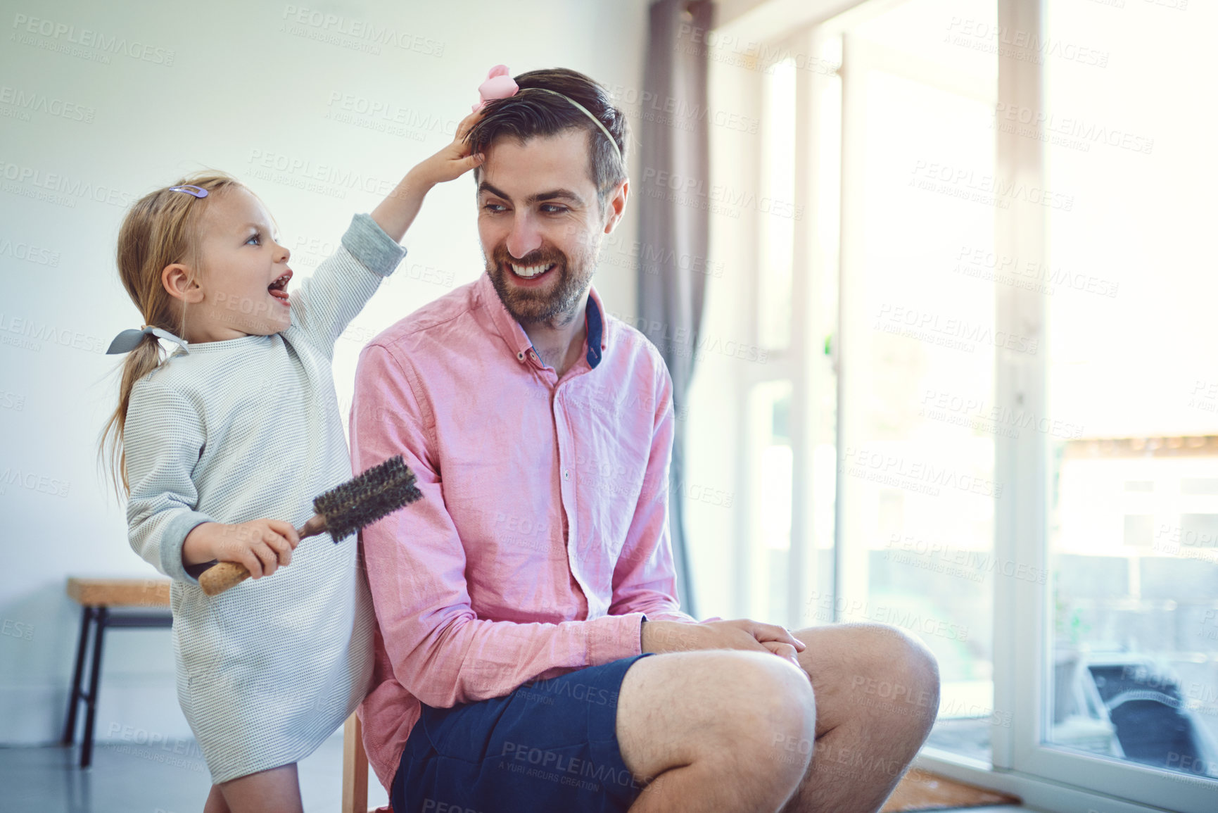 Buy stock photo Shot of an adorable little girl brushing her father’s hair at home