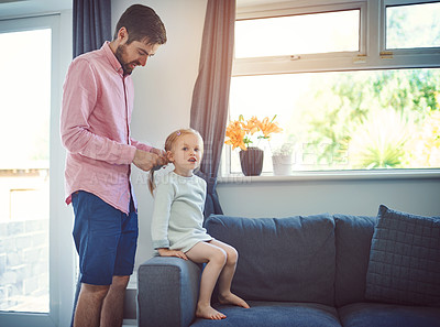 Buy stock photo Shot of a father brushing his daughter’s hair at home