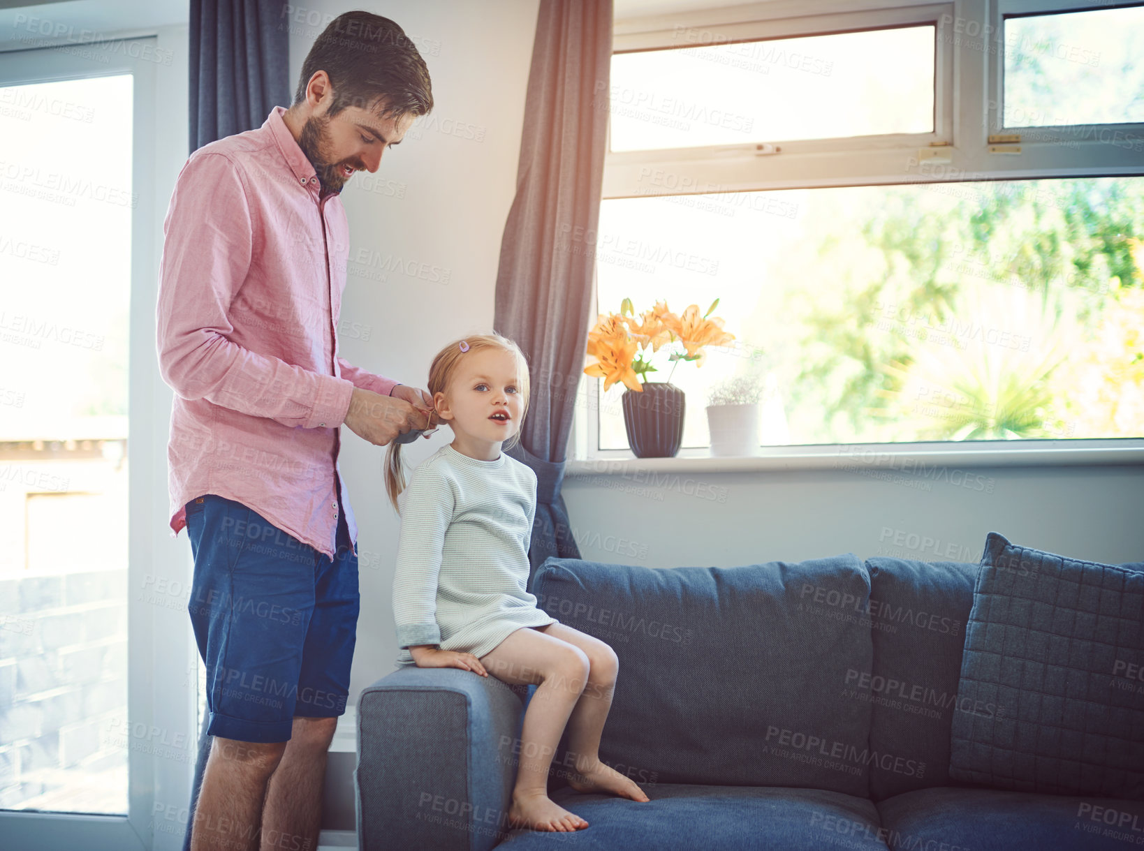 Buy stock photo Shot of a father brushing his daughter’s hair at home