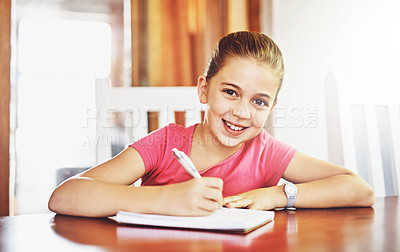 Buy stock photo Portrait, happy child and writing at table for school, studying and education in house for knowledge. Notebook, girl and student for learning, exam and homeschool for development with pride