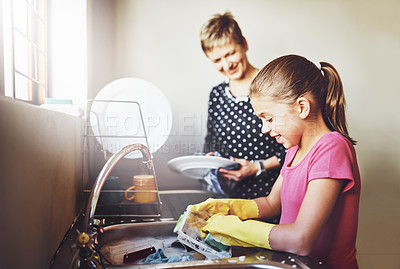 Buy stock photo Kitchen, mother and daughter washing dishes together with help, learning or teaching at basin. Housework, mom and girl in home cleaning at sink with smile, support and morning housekeeping chores