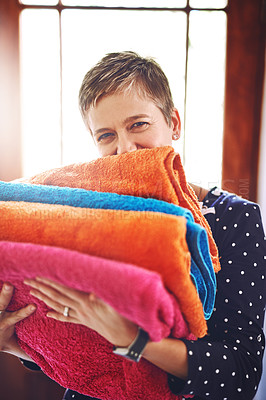 Buy stock photo Laundry, woman and clean towels in portrait after washing, housework and folded material in the morning. Home, housekeeping and cleaner or female person with color fabric or soft cloth as routine