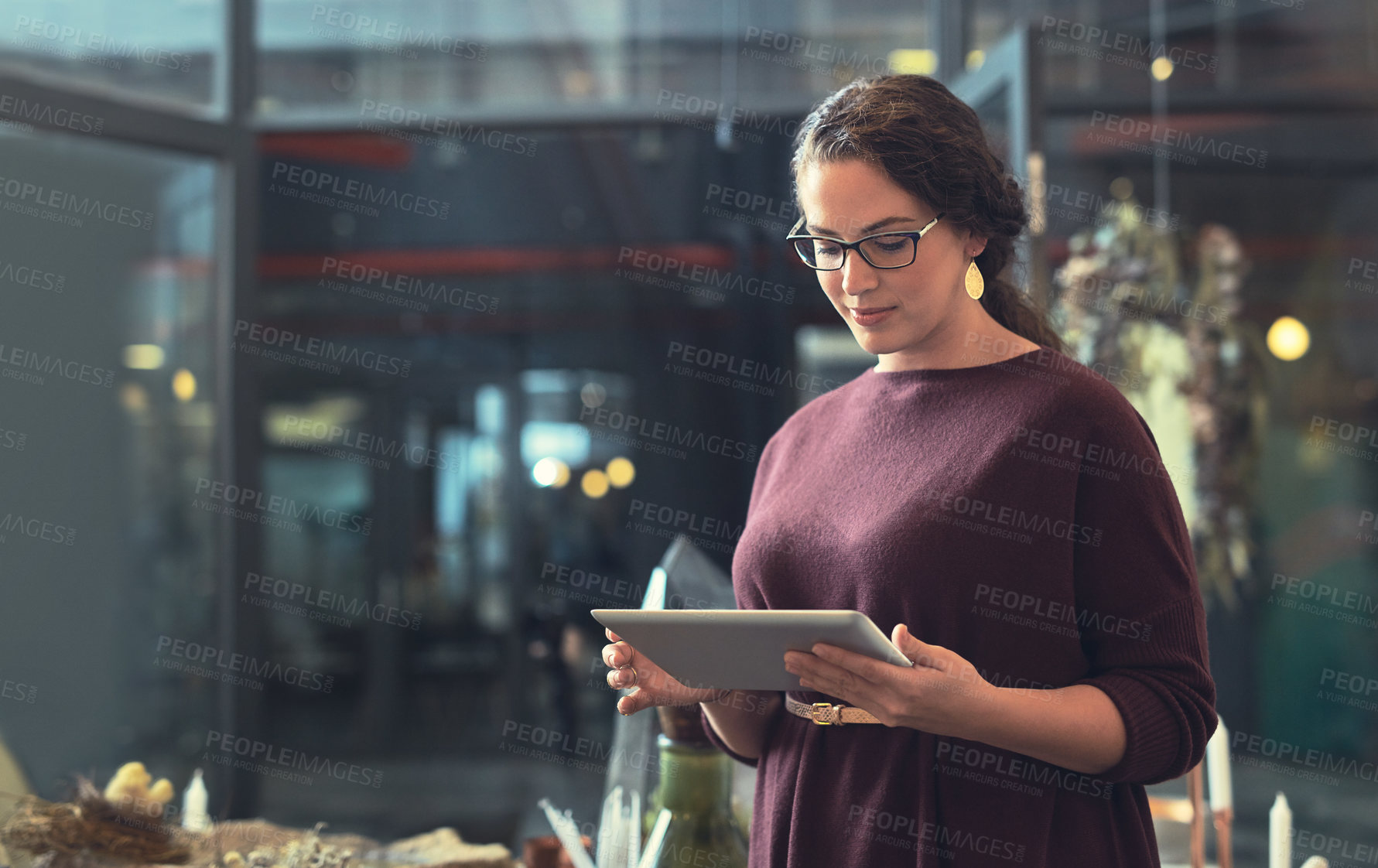 Buy stock photo Cropped shot of an attractive young female entrepreneur using a tablet in her store