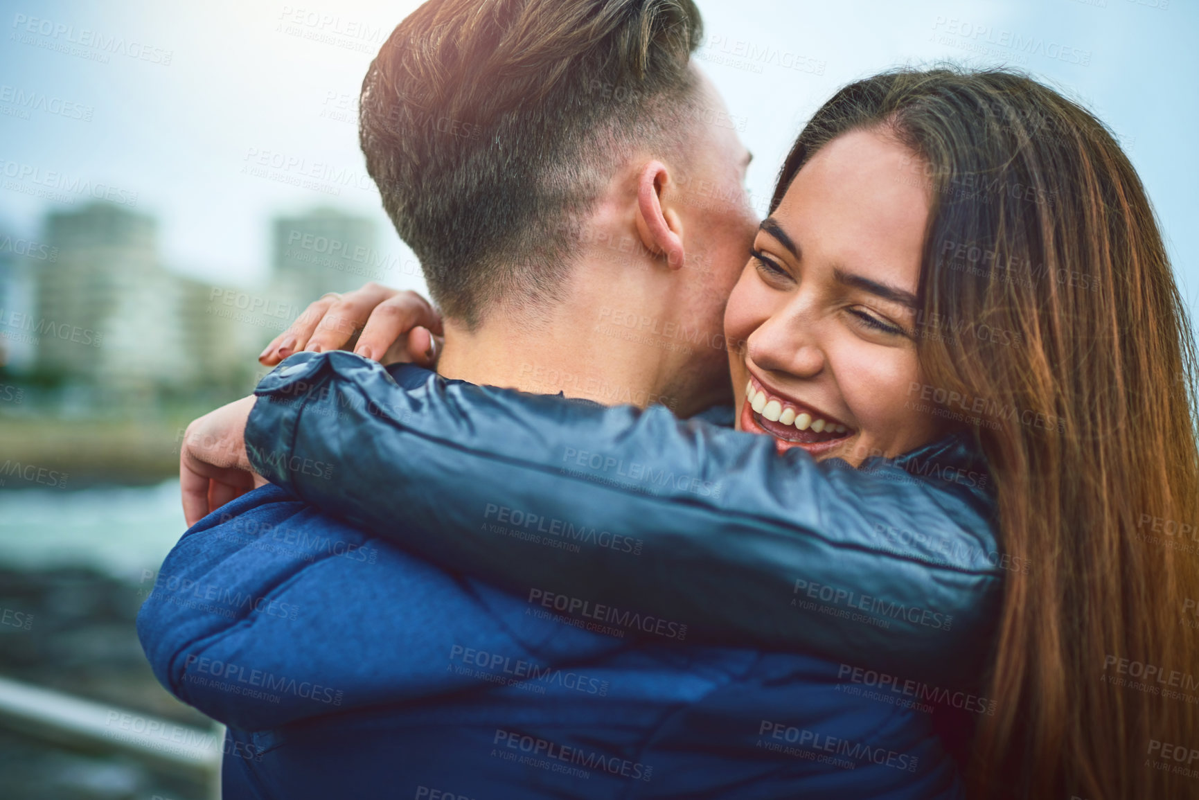 Buy stock photo Couple, hug and outdoor with laugh, love and city date with bonding and by town pier. Happy, romance and young woman with travel and holiday in winter with support and care in Chicago with joy