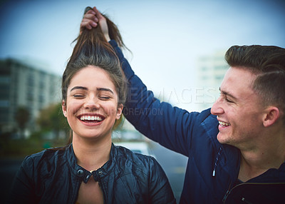 Buy stock photo Happy, couple and pull hair for playful games, crazy memory and bonding together in city. Woman, man and goofy humor for comic travel with love commitment, blue sky and funny gesture of date outdoor