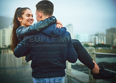 Buy stock photo Happy, couple and carry woman outdoor for relationship, romance date and bonding together in city. Smile, man and partner care for support or safety, commitment and young love of anniversary passion