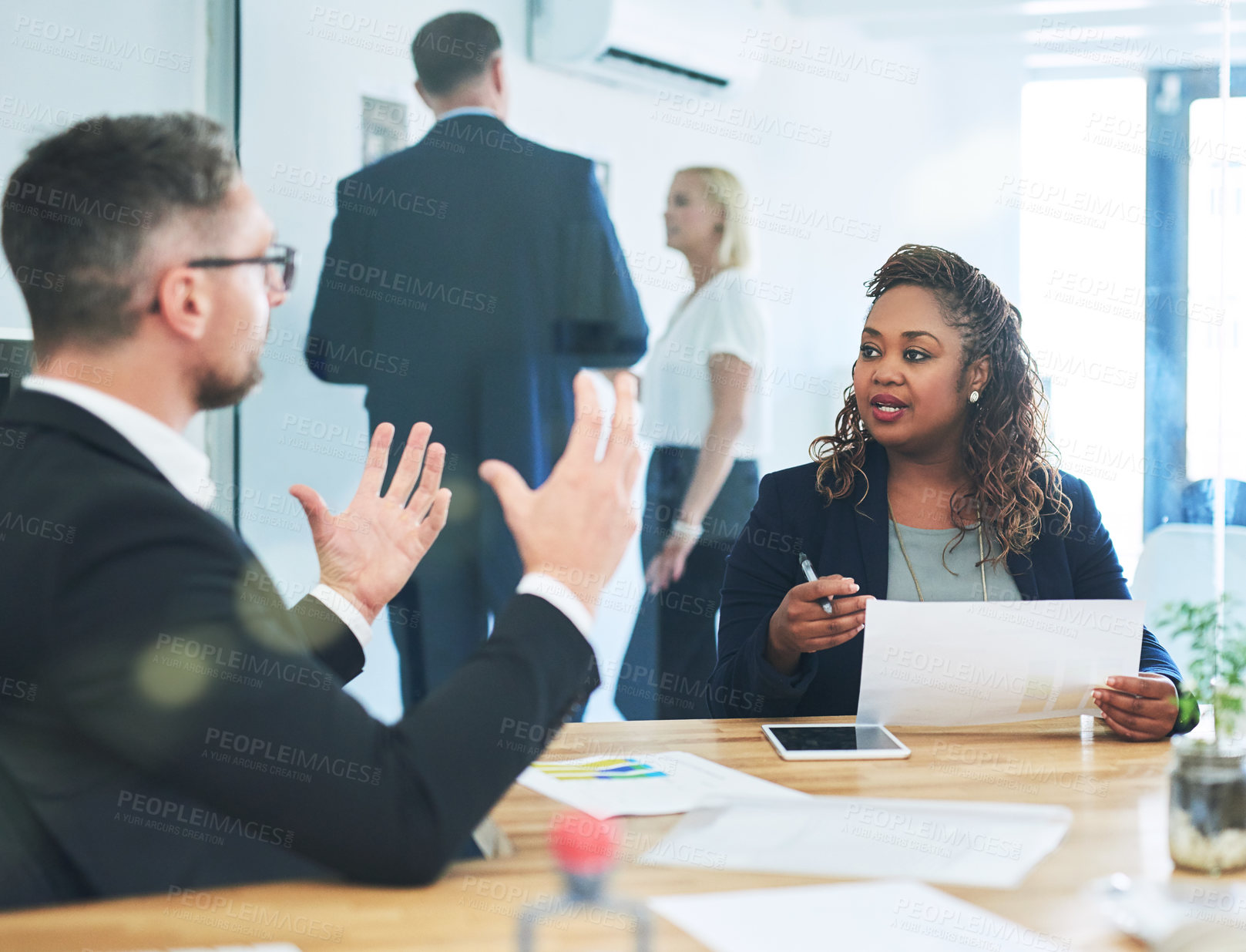 Buy stock photo Cropped shot of a group of corporate colleagues sitting in the boardroom during a meeting