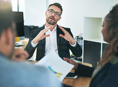 Buy stock photo Cropped shot of a group of corporate colleagues sitting in the boardroom during a meeting