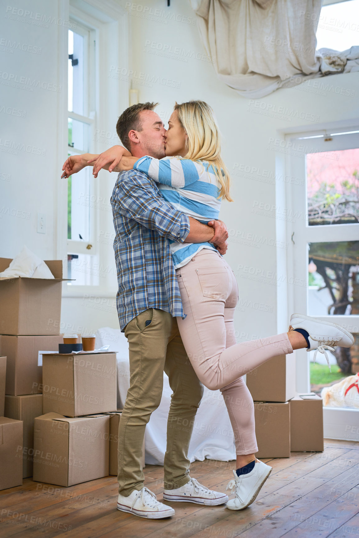 Buy stock photo Moving, couple and kiss for home, box and man in living room, happy and mortgage for real estate in apartment. Woman, new house and property with packages, romance and loan for investment in USA