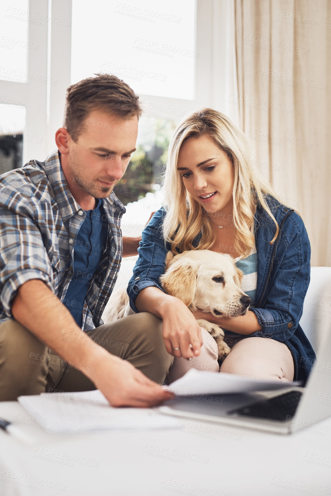 Buy stock photo Shot of a young couple doing their finances together at home