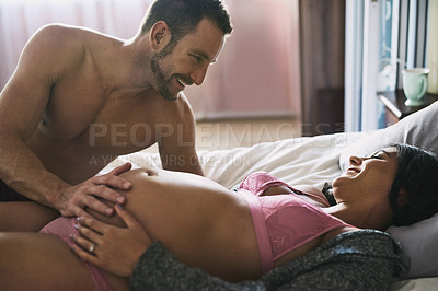 Buy stock photo Pregnant, couple and touching stomach on bed in home for bonding with baby, feeling kick and wellness. Maternal, people and excited for parenting in bedroom with lingerie, support and future family