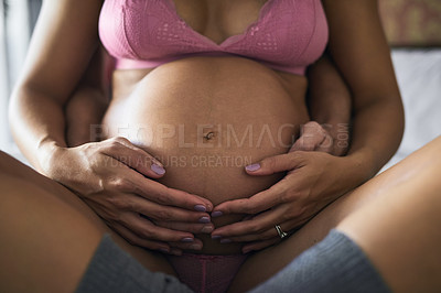 Buy stock photo Pregnancy, couple and hands on stomach for love, touch and safety with care in home. Future parents, pride and woman in underwear for growth, maternity and hug for protection or feeling baby kick