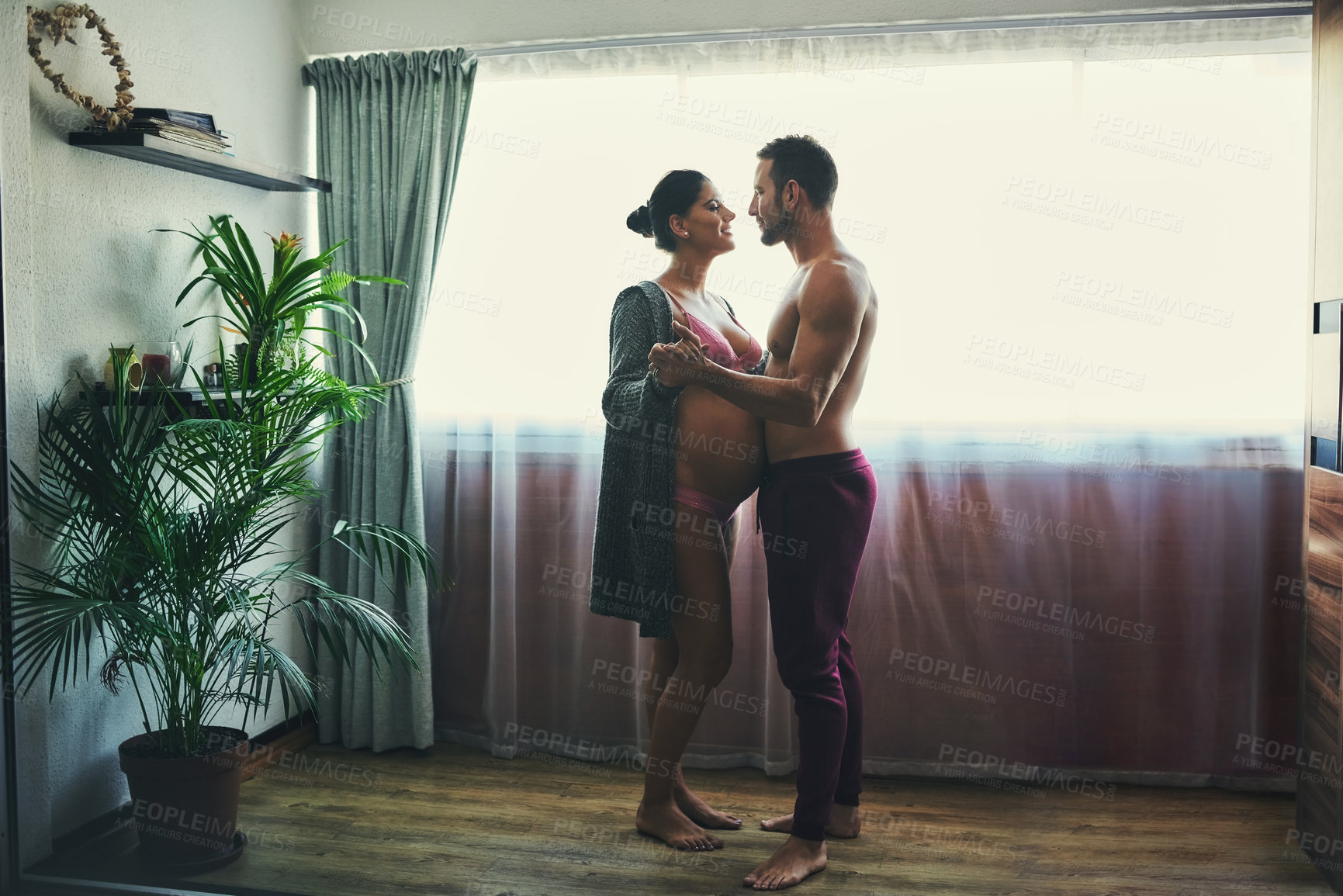 Buy stock photo Man, pregnant woman and dance in bedroom for prenatal care, bonding and love of pregnancy development. Couple, wife and stomach with underwear, healthy maternity and family intimacy at house