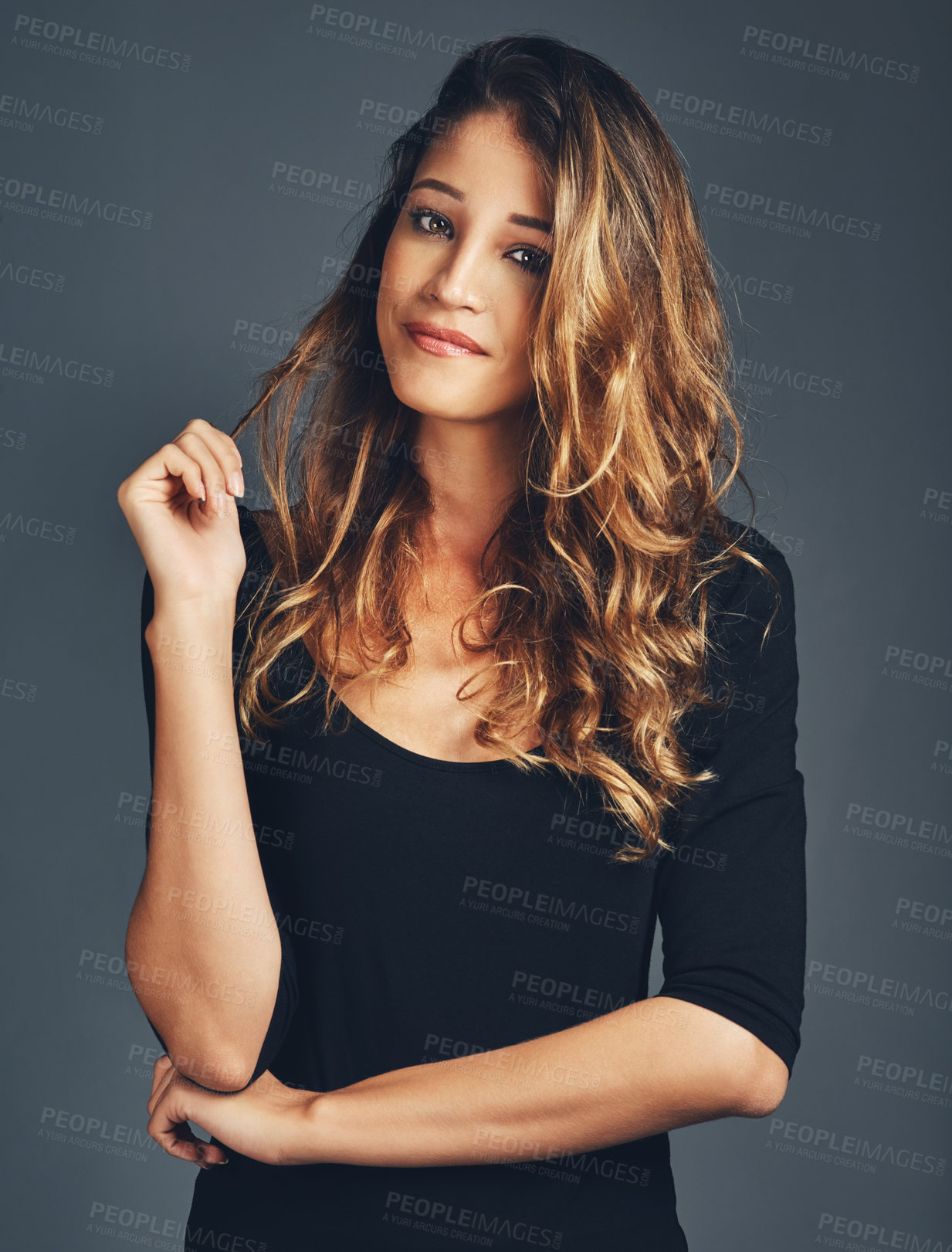 Buy stock photo Beauty, portrait and a woman playing with hair in studio with a smile, makeup and cosmetics for skin glow. Aesthetic female model with salon results, shine and growth shampoo on a grey background