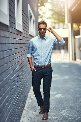 Buy stock photo Portrait of a handsome young businessman standing against a grey facebrick wall