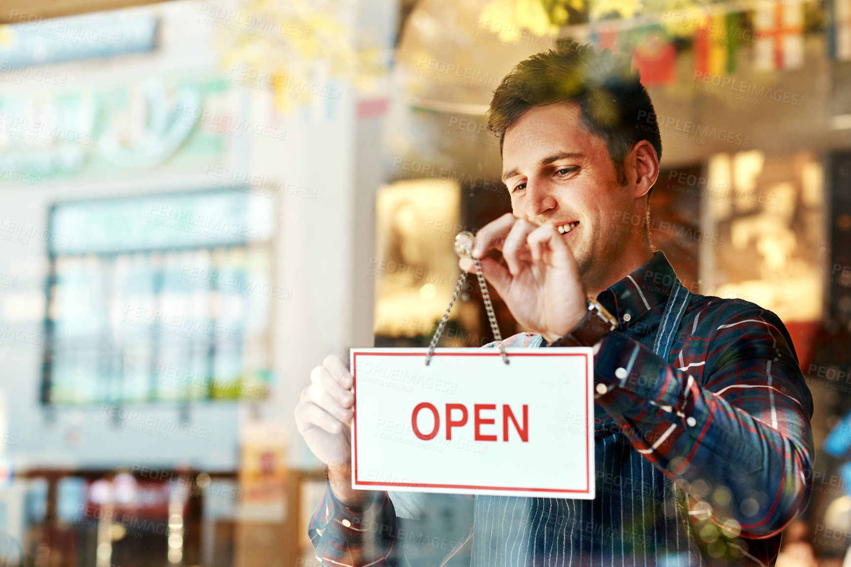 Buy stock photo Coffee shop, open sign and a man small business owner standing a glass door for service or hospitality. Cafe, manager or employee with a happy male waiter proud to be opening a new restaurant