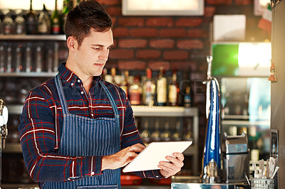 Buy stock photo Cropped shot of a restaurant owner using a digital tablet