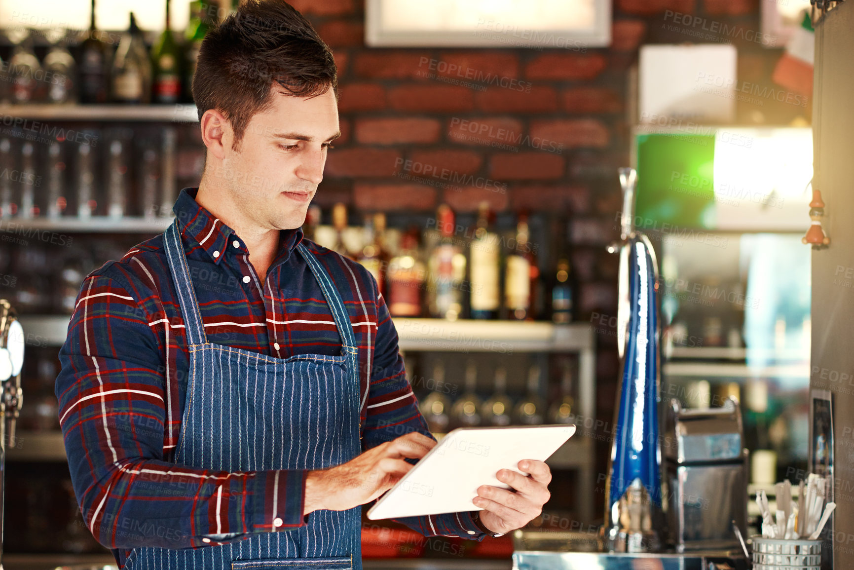 Buy stock photo Cropped shot of a restaurant owner using a digital tablet