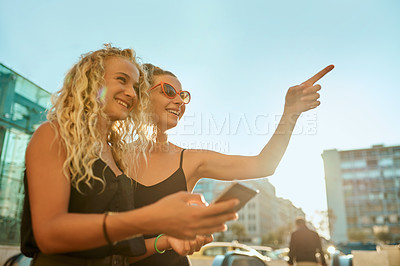 Buy stock photo Happy girl, friends or pointing with phone in city for sightseeing, travel or tourisrm. Young, female person or tourists with smile for outdoor view, location or destination together in an urban town