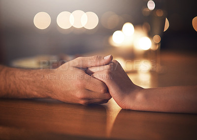 Buy stock photo Cropped shot of a couple holding hands against a night time background