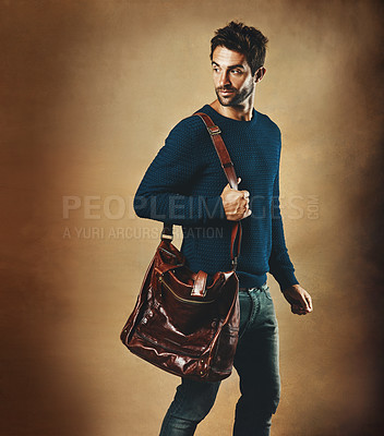 Buy stock photo Serious, thinking and man with bag for fashion isolated on a brown background mockup space in studio. Idea, vision and person in casual clothes, jeans or dream of trendy style with leather for travel