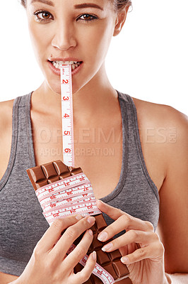 Buy stock photo Woman, chocolate and bite with measuring tape for unhealthy diet with junk food in studio. Female person, eating and sugar craving or weight gain with snack or sweet temptation on white background