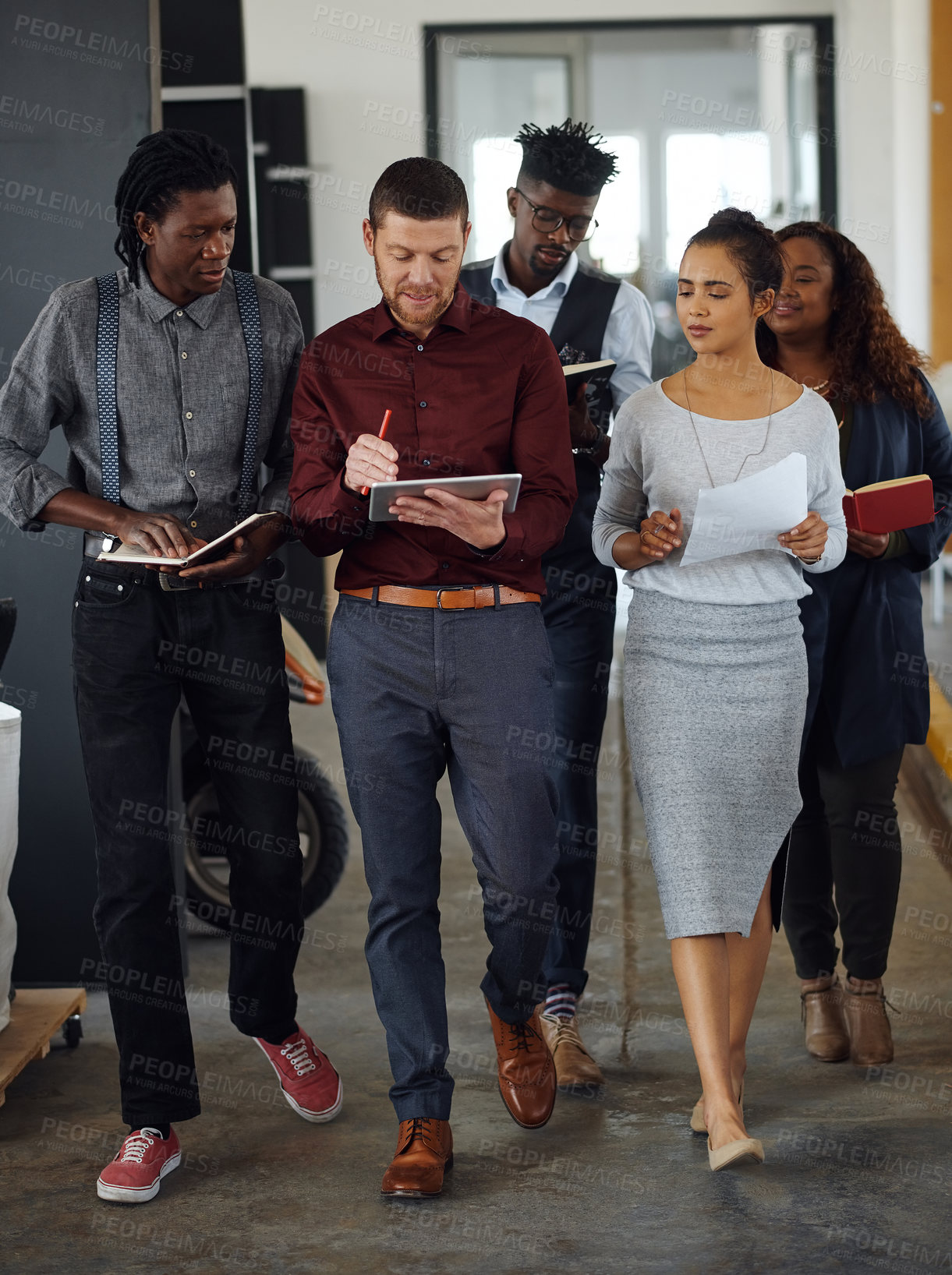 Buy stock photo Shot of a group of businesspeople having a discussion while walking together in an office