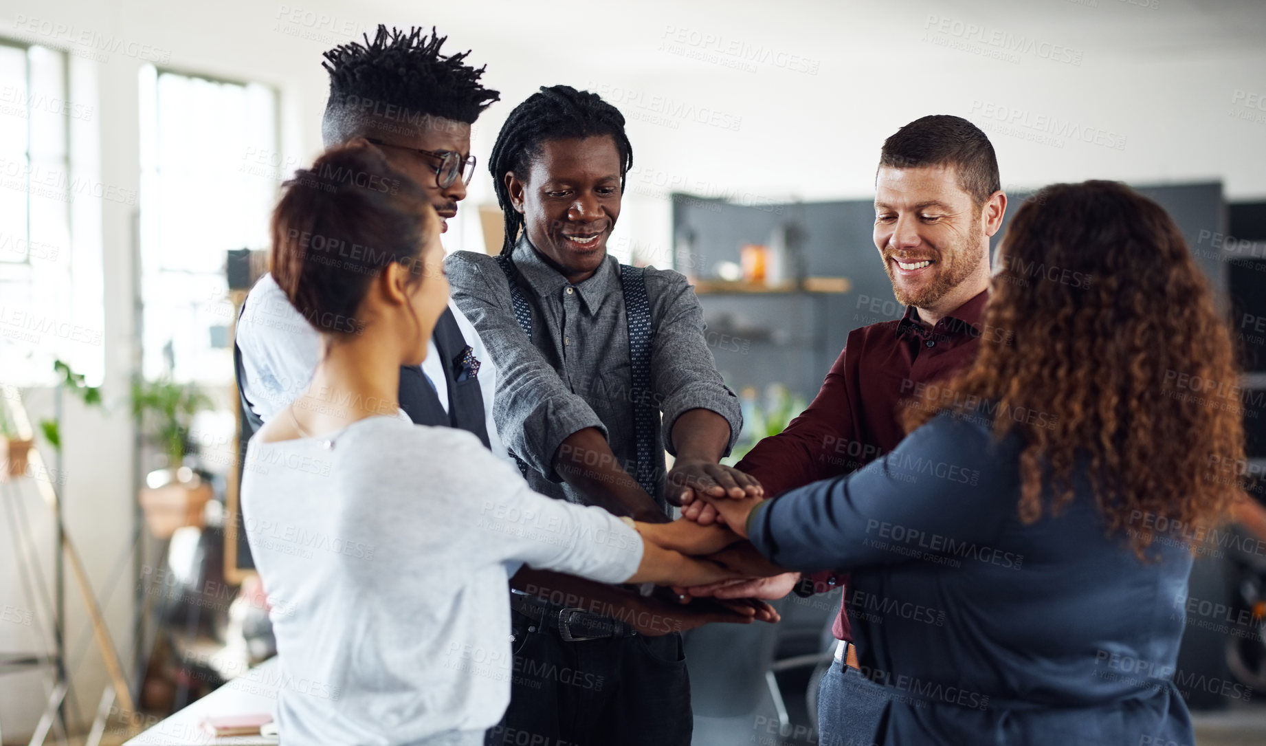 Buy stock photo Shot of a group of businesspeople joining their hands together in a huddle